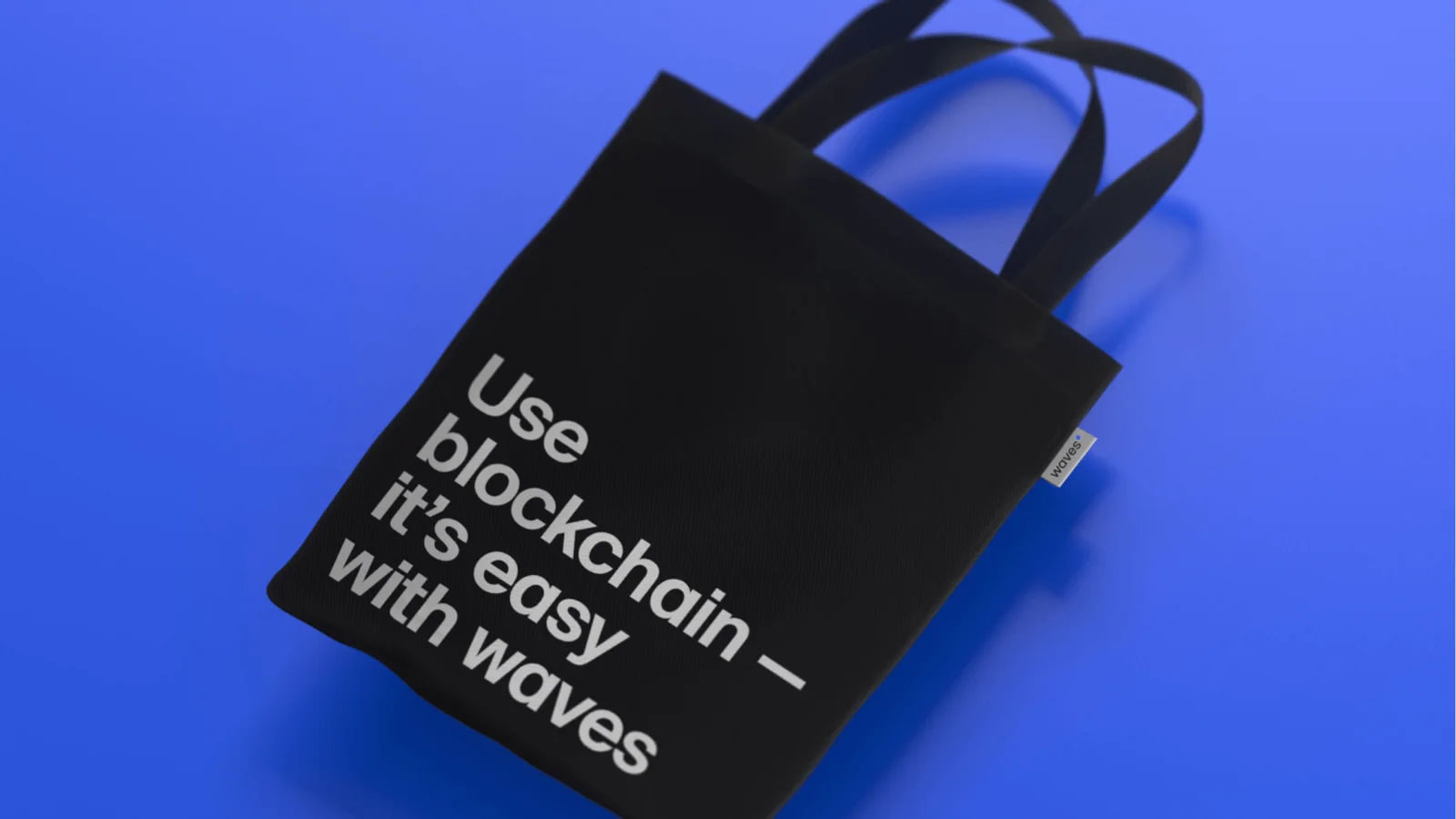 A black tote bag on blue: Use blockchain, it’s easy with waves.